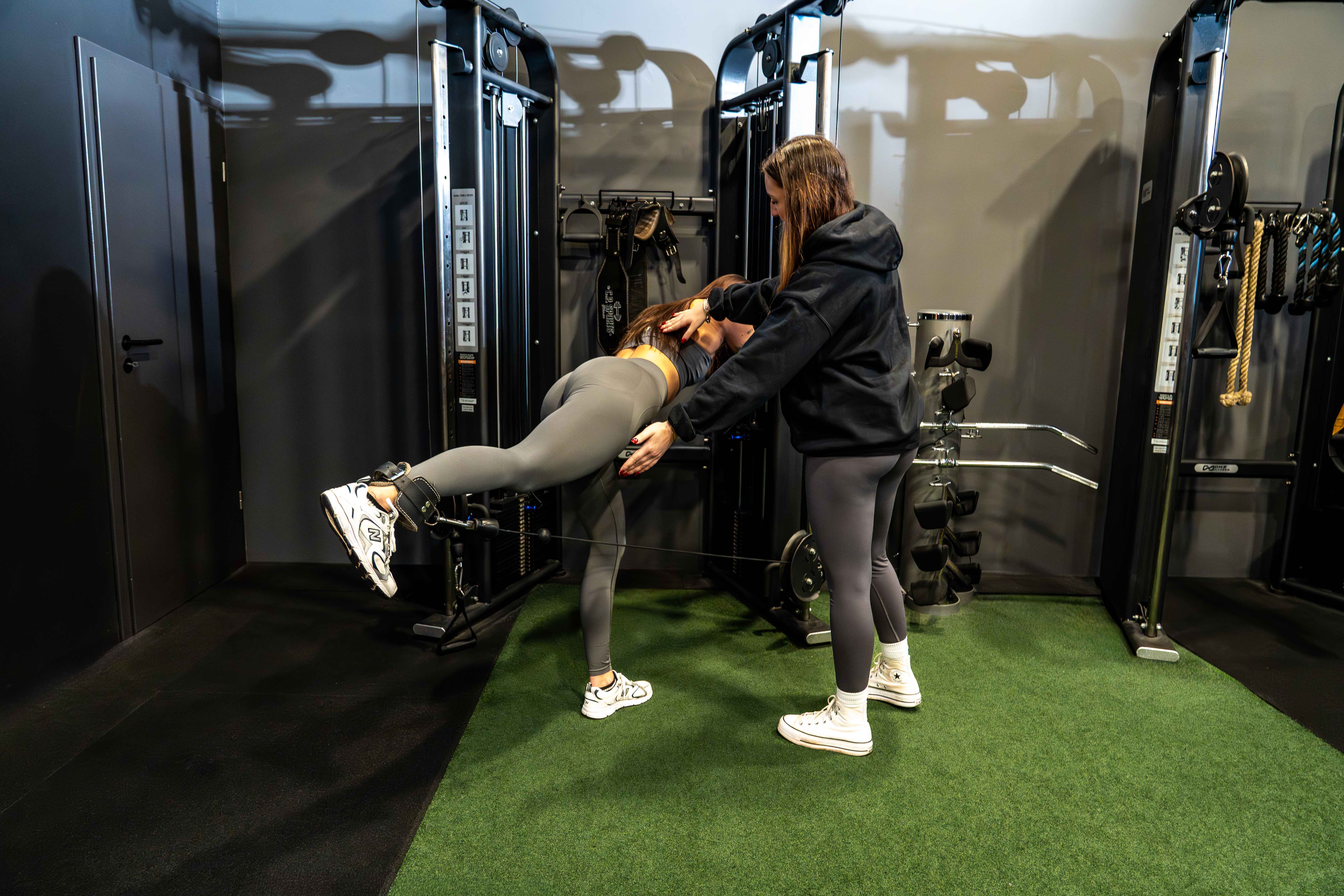 Individuelle Korrektur bei Kabelzug-Übungen durch Coach